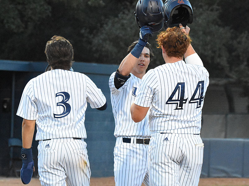 Sammy Diaz (44) and Matt King (3) greet Leyton Barry at home plate after all three scored on Barry's second-inning home run. UTSA baseball beat Southern 15-4 on Friday, March 4, 2022, at Roadrunner Field. - photo by Joe Alexander